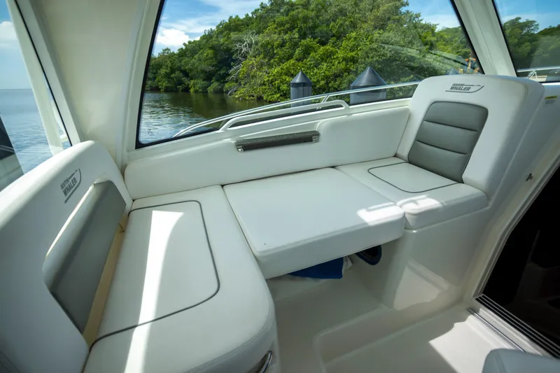 Slide: The Image of 2014 Boston Whaler 315 Conquest interior seating with scenic water view. - 11