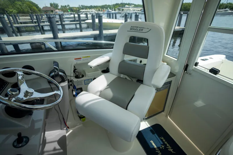 Slide: The Image of Interior of 2014 Boston Whaler 315 Conquest boat with captain's chair and steering wheel. - 3