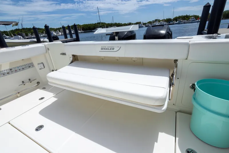 Slide: The Image of 2014 Boston Whaler 315 Conquest boat interior with foldable seat and ocean view. - 8