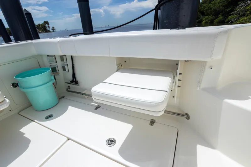 Slide: The Image of 2014 Boston Whaler 315 Conquest boat interior with foldable seat and blue bucket. - 9
