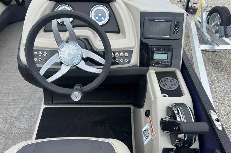 Slide: The Image of 2023 Barletta C22 boat dashboard with steering wheel, gauges, and control panel. - 11