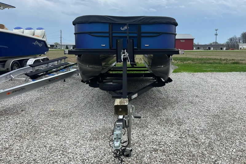 Slide: The Image of 2023 Barletta C22 pontoon boat on trailer, parked on gravel lot. - 2