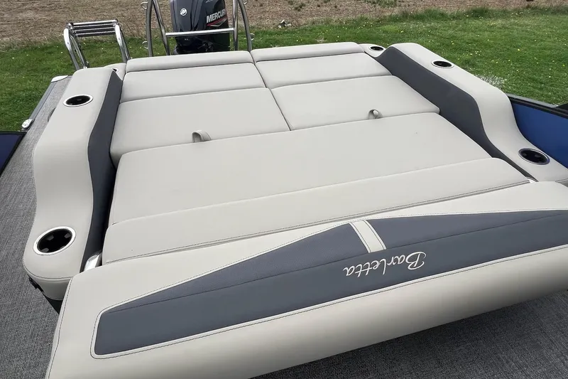Slide: The Image of 2023 Barletta C22 boat with cushioned seating and cup holders, featuring a Mercury engine. - 22