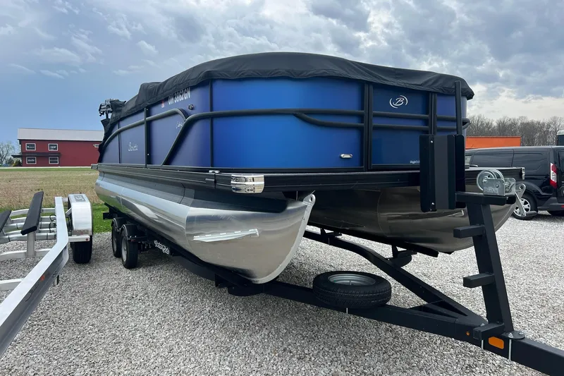 Slide: The Image of 2023 Barletta C22 pontoon boat on trailer, parked on gravel lot. - 4
