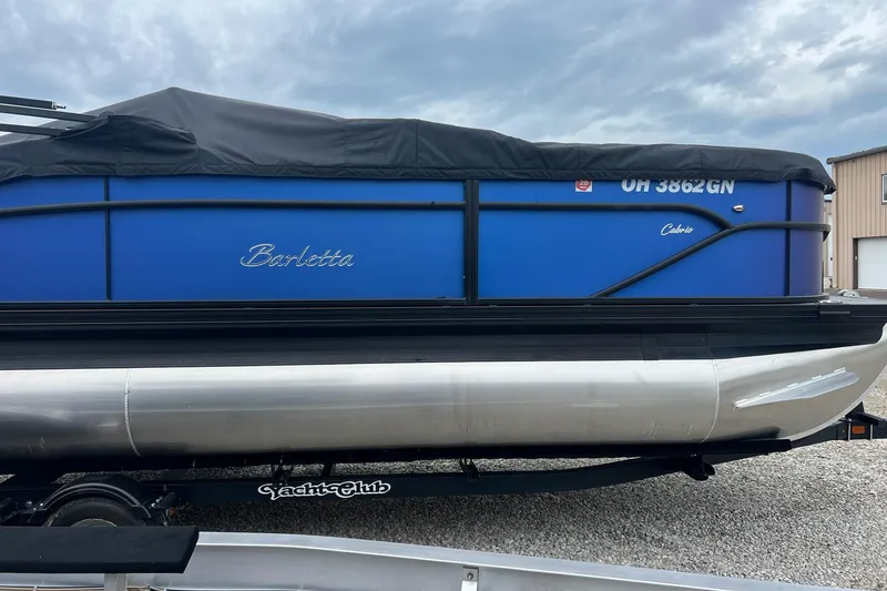 Slide: The Image of 2023 Barletta C22 pontoon boat with blue exterior on a trailer. - 5