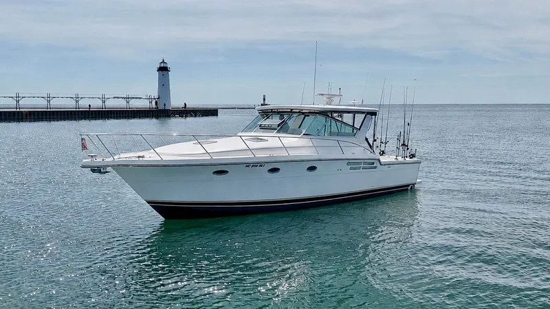 The Image of 1999 Tiara Yachts 4100 Open near a lighthouse on calm waters. - 0