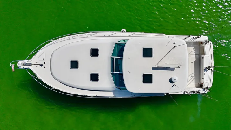 Slide: The Image of Aerial view of a 1999 Tiara Yachts 4100 Open on green water. - 14