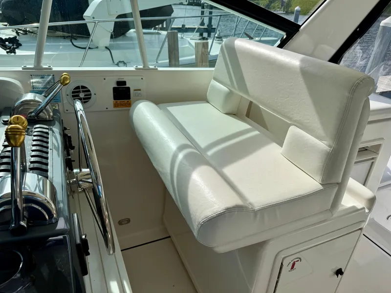 Slide: The Image of Interior of a 1999 Tiara Yachts 4100 Open, helm station with white seating. - 27