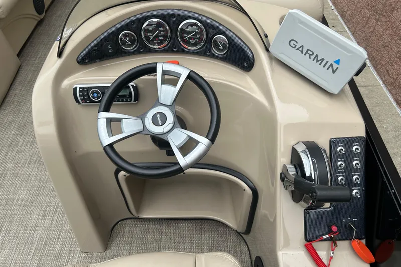 Slide: The Image of 2019 Bentley Pontoons 243 dashboard with steering wheel, Garmin device, and control panel. - 13