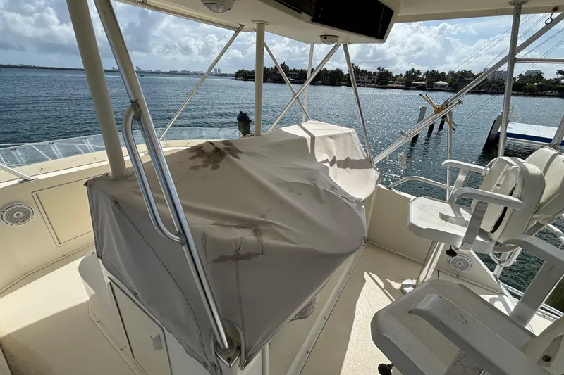 Slide: The Image of Flybridge of 1990 Viking 43 Convertible yacht with covered controls, overlooking serene waters. - 10