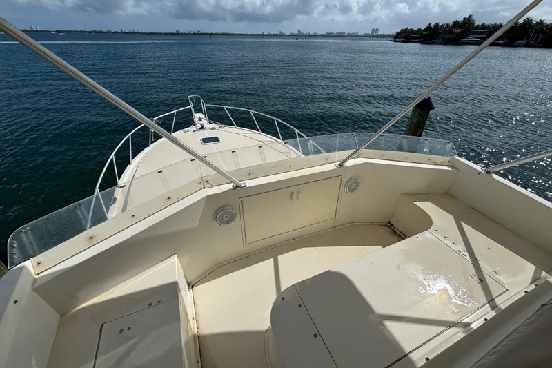 Slide: The Image of 1990 Viking 43 Convertible yacht deck overlooking calm waters and distant shoreline. - 12