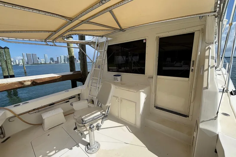 Slide: The Image of 1990 Viking 43 Convertible yacht deck with seating, overlooking city skyline and water. - 17