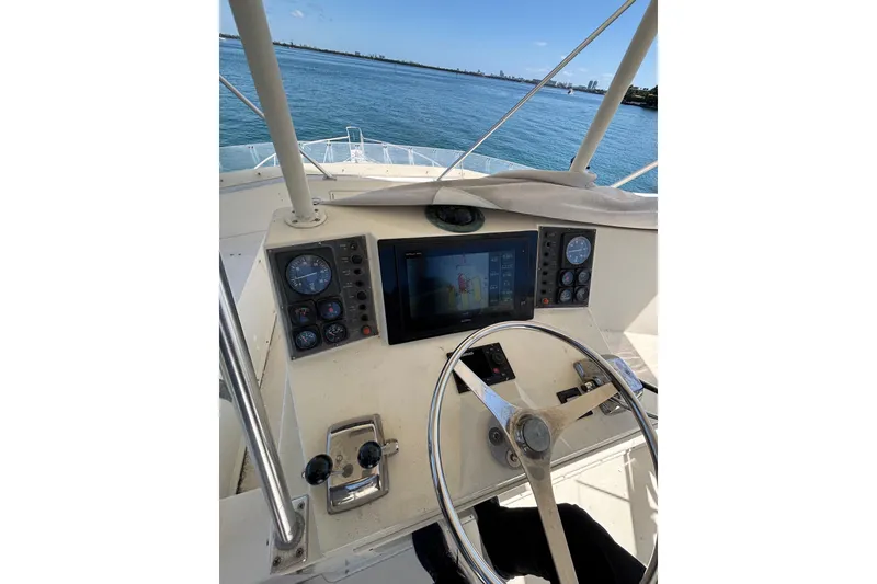 Slide: The Image of Cockpit view of a 1990 Viking 43 Convertible yacht with steering wheel and navigation instruments. - 19