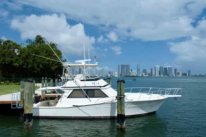 Slide: The Image of 1990 Viking 43 Convertible yacht docked with city skyline in background. - 2