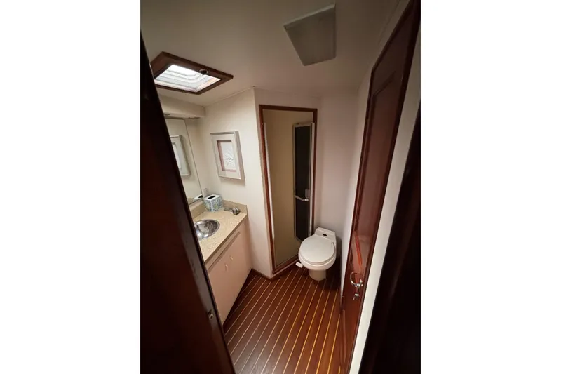 Slide: The Image of Bathroom interior of a 1990 Viking 43 Convertible yacht, featuring wood flooring and compact design. - 21