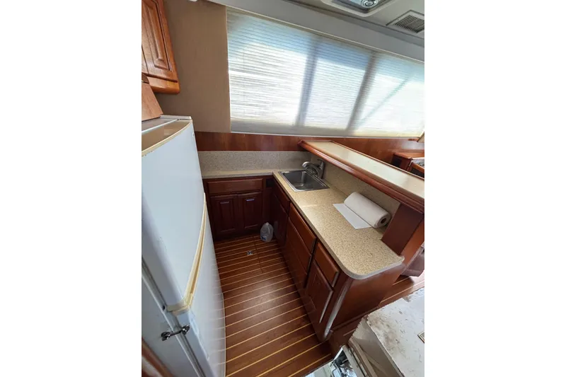 Slide: The Image of 1990 Viking 43 Convertible yacht kitchen with wood cabinetry and countertop. - 23