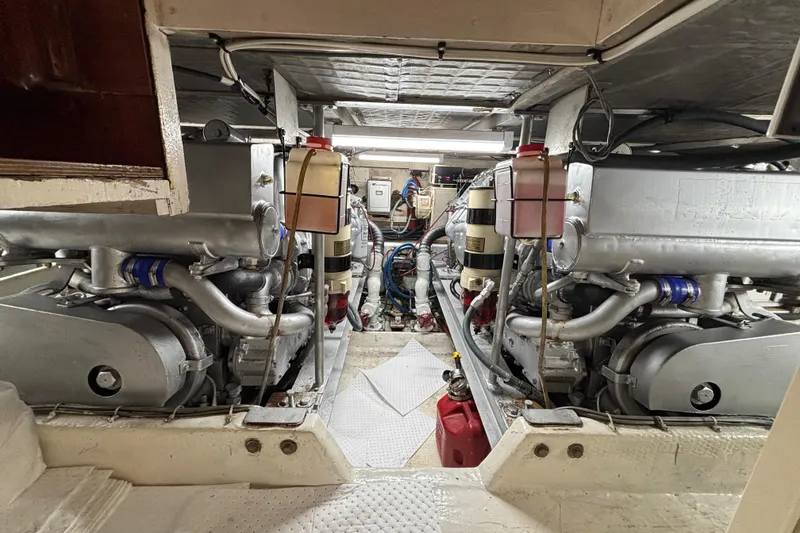 Slide: The Image of Engine room of a 1990 Viking 43 Convertible yacht, showcasing dual engines and mechanical components. - 26