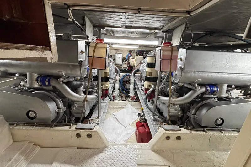 Slide: The Image of Engine room of a 1990 Viking 43 Convertible yacht, showcasing dual engines and mechanical components. - 27