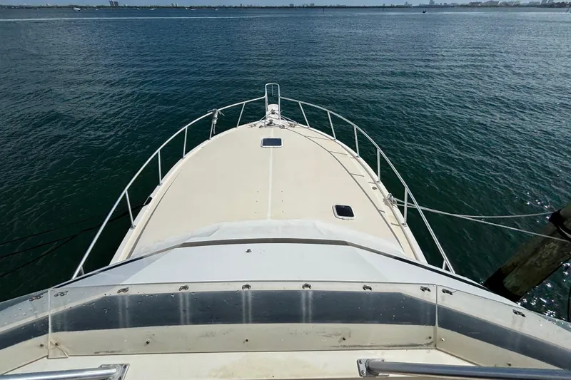 Slide: The Image of Bow view of a 1990 Viking 43 Convertible yacht on calm waters. - 5
