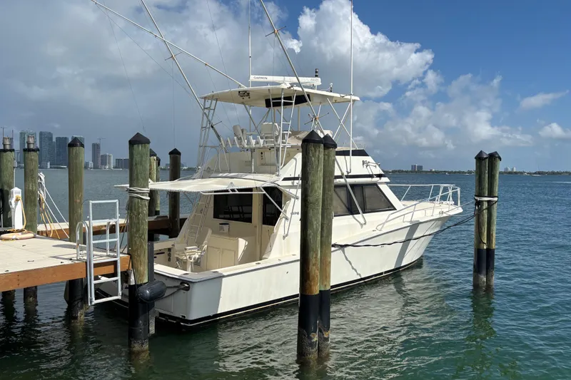 Slide: The Image of 1990 Viking 43 Convertible yacht docked at marina under clear blue sky. - 6