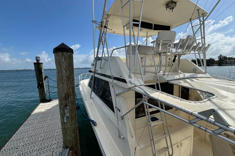 Slide: The Image of 1990 Viking 43 Convertible yacht docked by the water on a sunny day. - 8