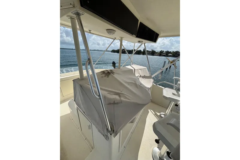 Slide: The Image of 1990 Viking 43 Convertible yacht helm station with covered controls, overlooking serene waters. - 9