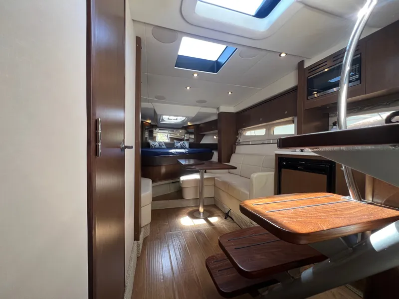 Slide: The Image of Interior of 2018 Sea Ray Sundancer 350 Coupe with wood flooring and leather seating. - 44
