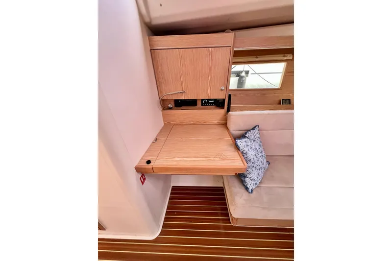 Slide: The Image of Interior of 2016 Hanse 455 yacht with wooden desk and cushioned seating. - 104