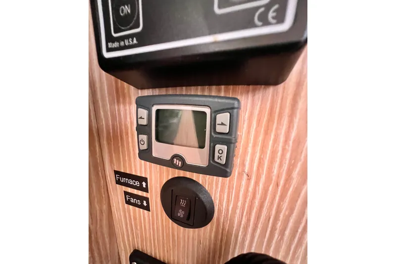 Slide: The Image of Control panel on a 2016 Hanse 455 yacht, featuring furnace and fan switches. - 113