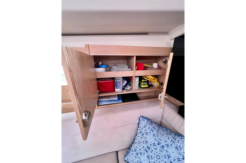 Slide: The Image of Open wooden cabinet on 2016 Hanse 455 yacht, displaying organized storage shelves. - 121