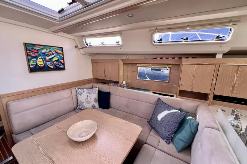 Slide: The Image of Interior of 2016 Hanse 455 yacht with cozy seating, cushions, and colorful boat painting. - 124