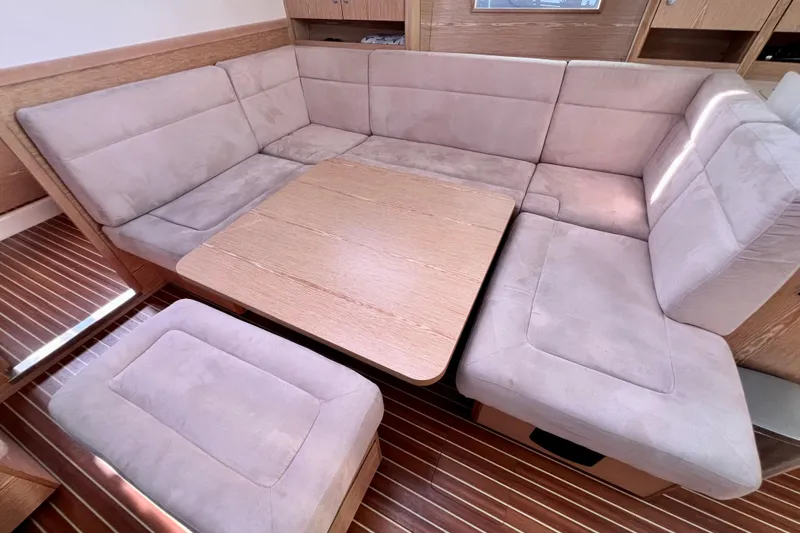 Slide: The Image of Interior of 2016 Hanse 455 yacht with beige cushioned seating and wooden table. - 126
