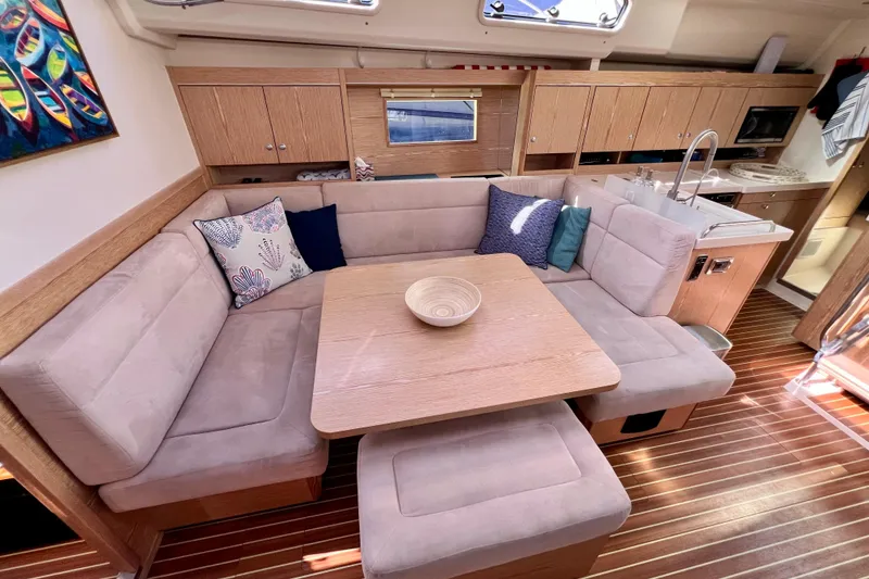 Slide: The Image of Interior of 2016 Hanse 455 yacht with cozy seating, wooden table, and modern kitchen. - 128