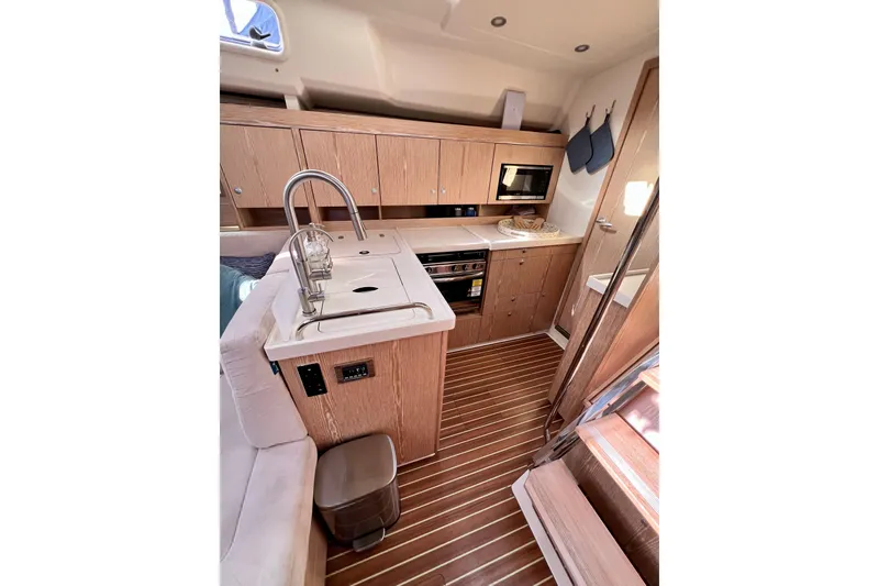Slide: The Image of Modern kitchen interior of 2016 Hanse 455 yacht with wood finish and appliances. - 133