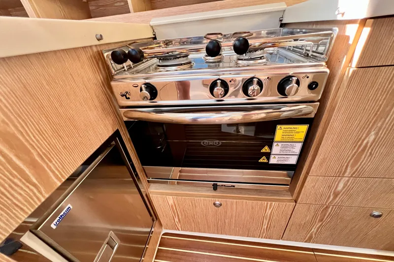 Slide: The Image of Modern kitchen in 2016 Hanse 455 yacht with stainless steel stove and wooden cabinetry. - 143