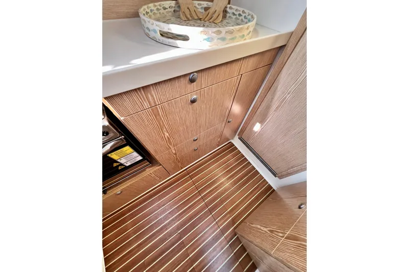 Slide: The Image of Interior of 2016 Hanse 455 yacht, featuring wooden cabinetry and striped flooring. - 145