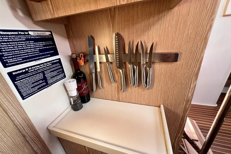 Slide: The Image of Kitchen area on a 2016 Hanse 455 yacht with knives and wine bottle. - 149