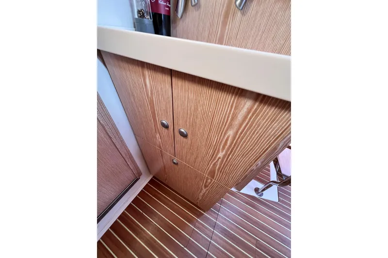 Slide: The Image of Interior of 2016 Hanse 455 yacht, featuring wooden cabinetry and striped flooring. - 150