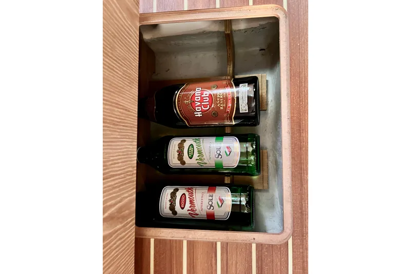 Slide: The Image of Bottles stored in a wooden compartment on a 2016 Hanse 455 yacht. - 152