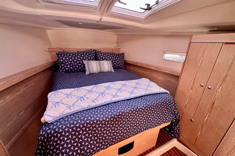 Slide: The Image of Cozy cabin interior of 2016 Hanse 455 yacht with patterned bedding and wooden cabinetry. - 155