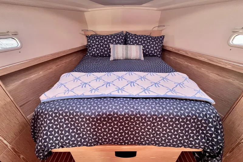 Slide: The Image of Cozy cabin interior of 2016 Hanse 455 yacht with patterned bedding and wooden accents. - 156