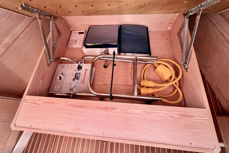 Slide: The Image of Storage compartment in a 2016 Hanse 455 yacht with cables and manuals. - 157