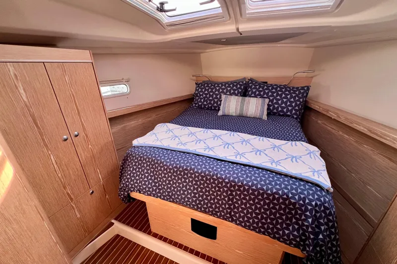 Slide: The Image of Cozy cabin interior of 2016 Hanse 455 yacht with stylish bedding and wooden cabinetry. - 158