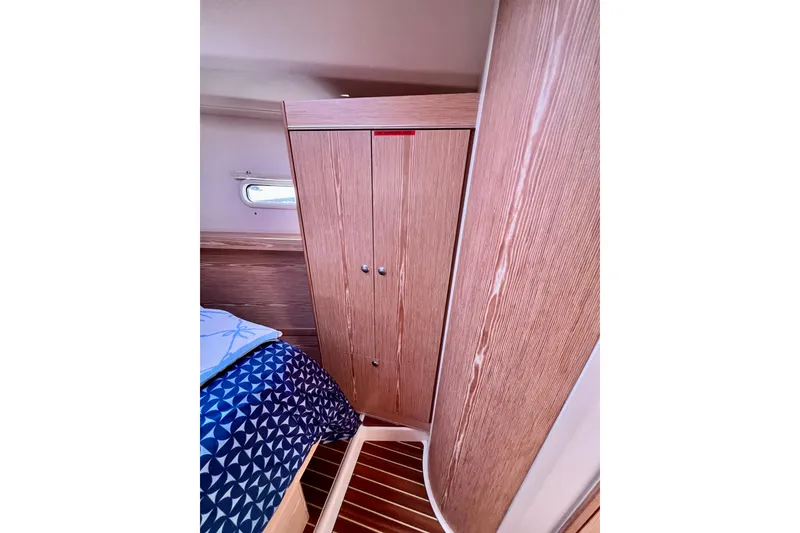 Slide: The Image of Interior of 2016 Hanse 455 yacht cabin with wooden wardrobe and patterned bedding. - 167
