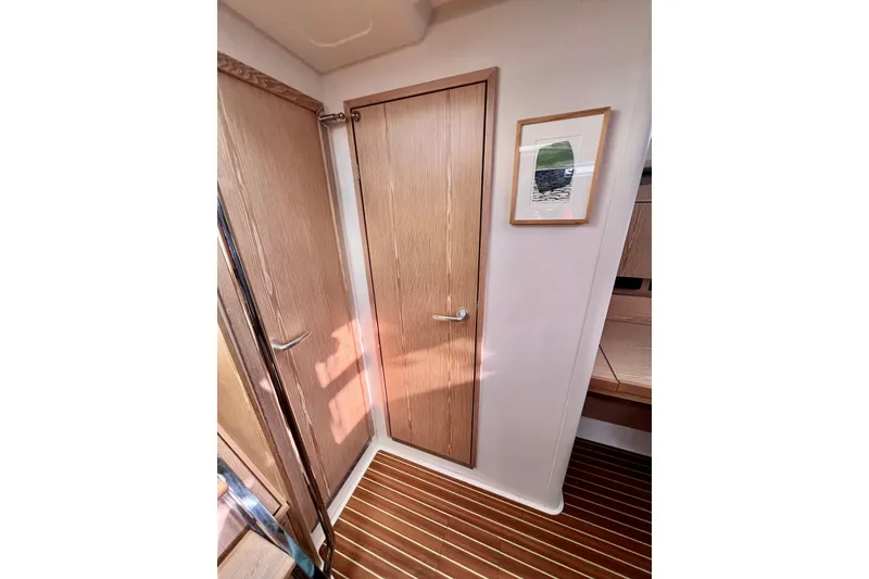 Slide: The Image of Interior of 2016 Hanse 455 yacht with wooden door and framed artwork. - 169