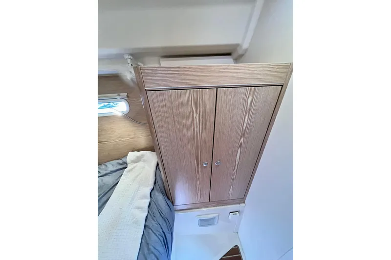 Slide: The Image of Interior of 2016 Hanse 455 yacht showing wooden cabinet and cozy bedding. - 173