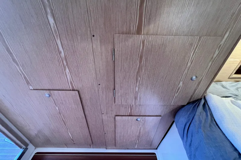 Slide: The Image of Wooden interior paneling with storage compartments in a 2016 Hanse 455 yacht cabin. - 175