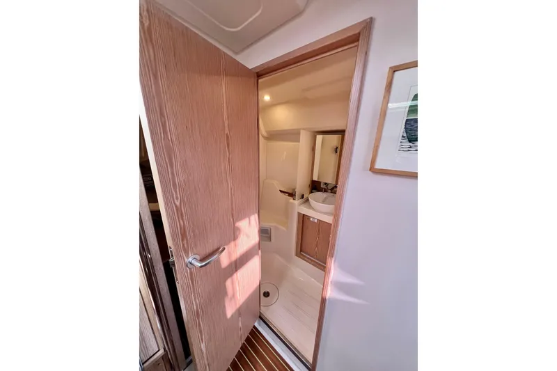 Slide: The Image of Interior view of 2016 Hanse 455 yacht bathroom with wooden door and modern sink. - 178