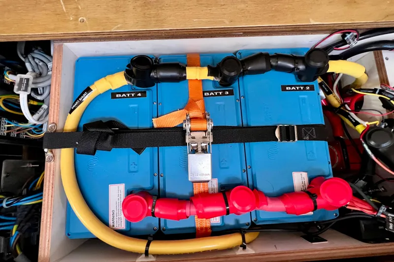 Slide: The Image of Battery compartment of a 2016 Hanse 455 yacht, featuring organized wiring and labeled batteries. - 196