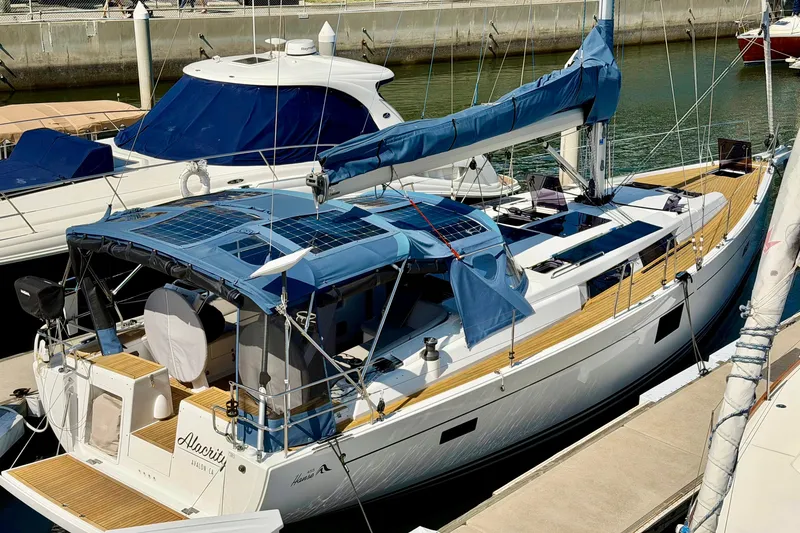 Slide: The Image of 2016 Hanse 455 yacht docked at marina with blue canopy and solar panels. - 2